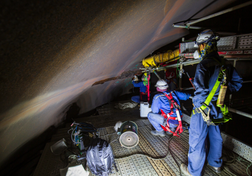 Equipe de resgatistas industriais atuando em espaço confinado com equipamentos de segurança NR-33.
