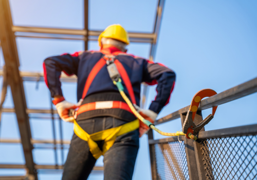 Profissional com equipamento de proteção contra quedas atuando em altura conforme NR-35