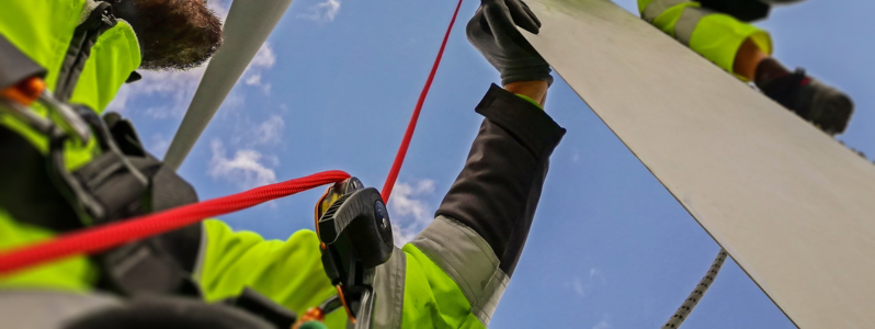 Técnica de acesso por corda sendo utilizada por profissional de alpinismo industrial em estrutura elevada