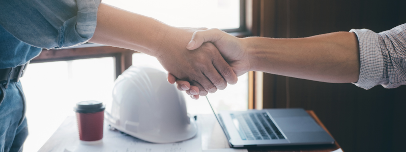 Empresários fechando contrato para projeto industrial com foco em conformidade legal e segurança