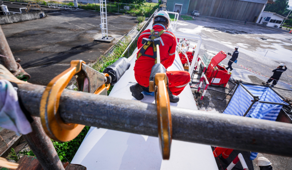 Trabalhador industrial utilizando linha de vida para segurança em altura durante manutenção em torre, em conformidade com a NR-35.